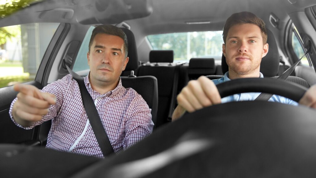 Autofahrschullehrer unterrichtet männlichen Fahrer