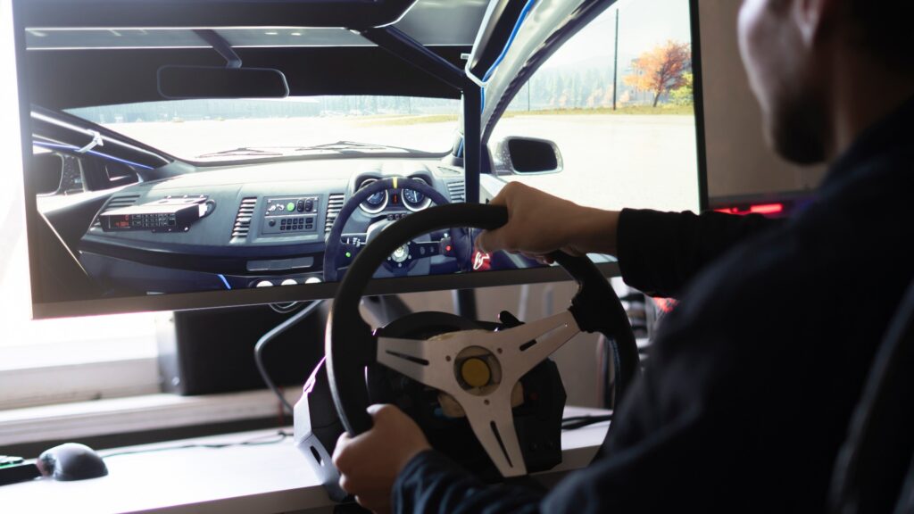 eine Person lernt das Autofahren mit Hilfe eines Auto-Computersimulators