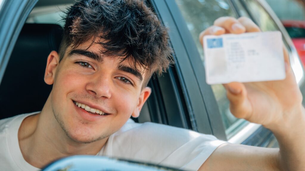 Fahranfänger im Auto lächelnd