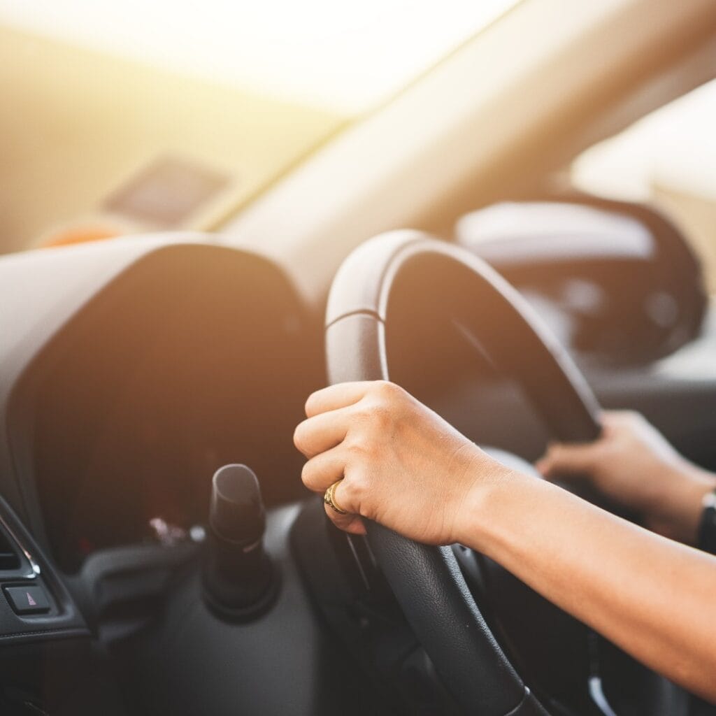 Nahaufnahme einer Frau am Steuer eines Autos auf der Straße